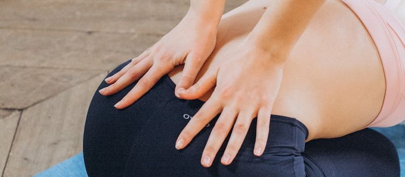 Person's hands placed on a yoga mat during practice.