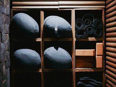 Yoga equipment like blocks and straps on a shelf.